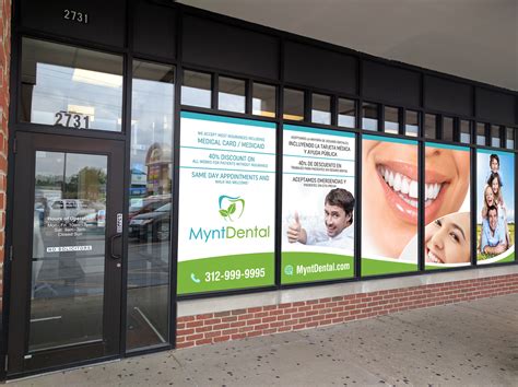 Dental office storefront with full-color branded window decals showing logo, services, and contact info