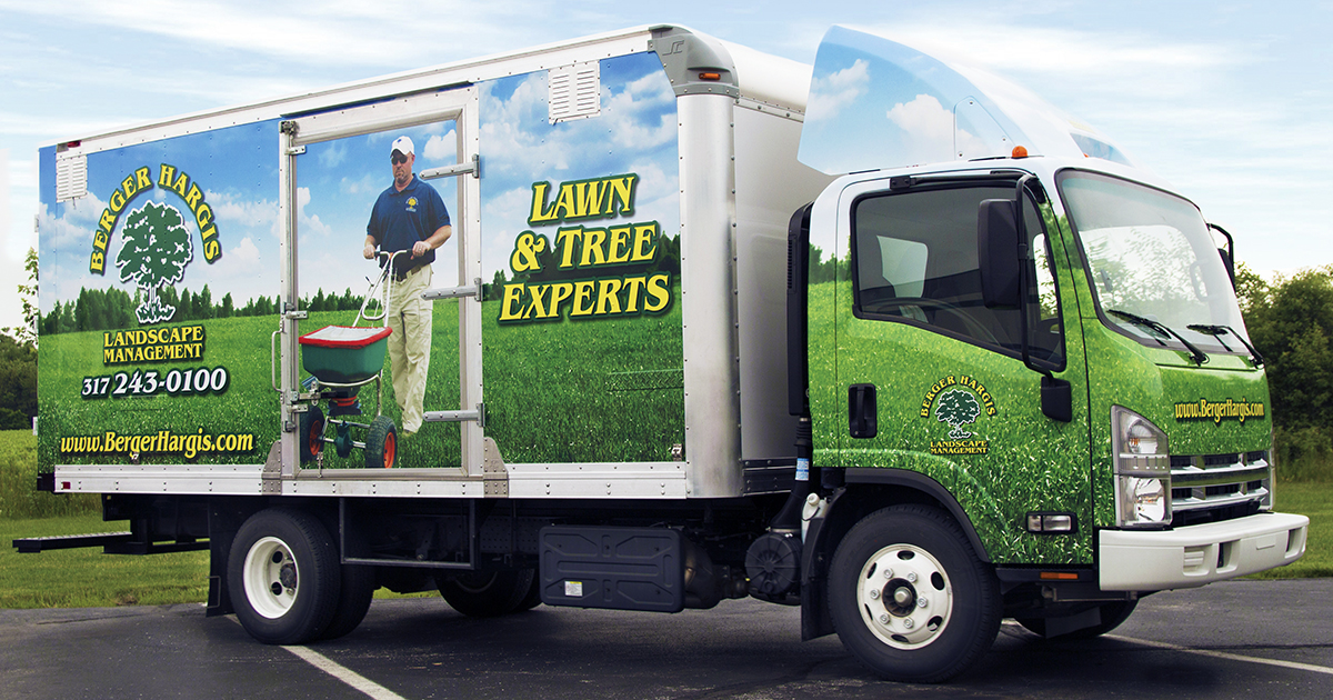 Full landscape management box truck wrap with green grass graphics, logo, phone number, and branded messaging